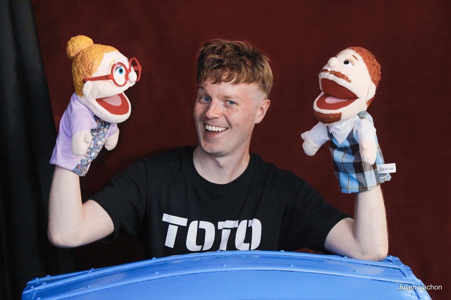 Toto avec les marionnettes de ses parents, bras écartés